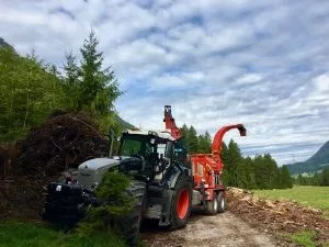 Hackmaschine vor Bergkulisse
